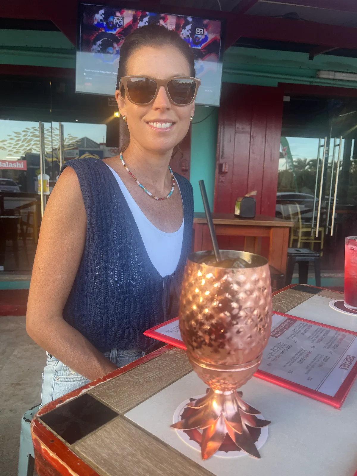 Woman having a cocktail at a beach bar in Aruba