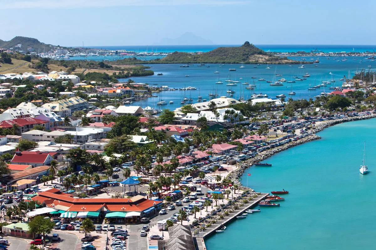 Elevated view of the colorful waterfront town and marina of Marigot bordering turquoise waters in St. Martin.