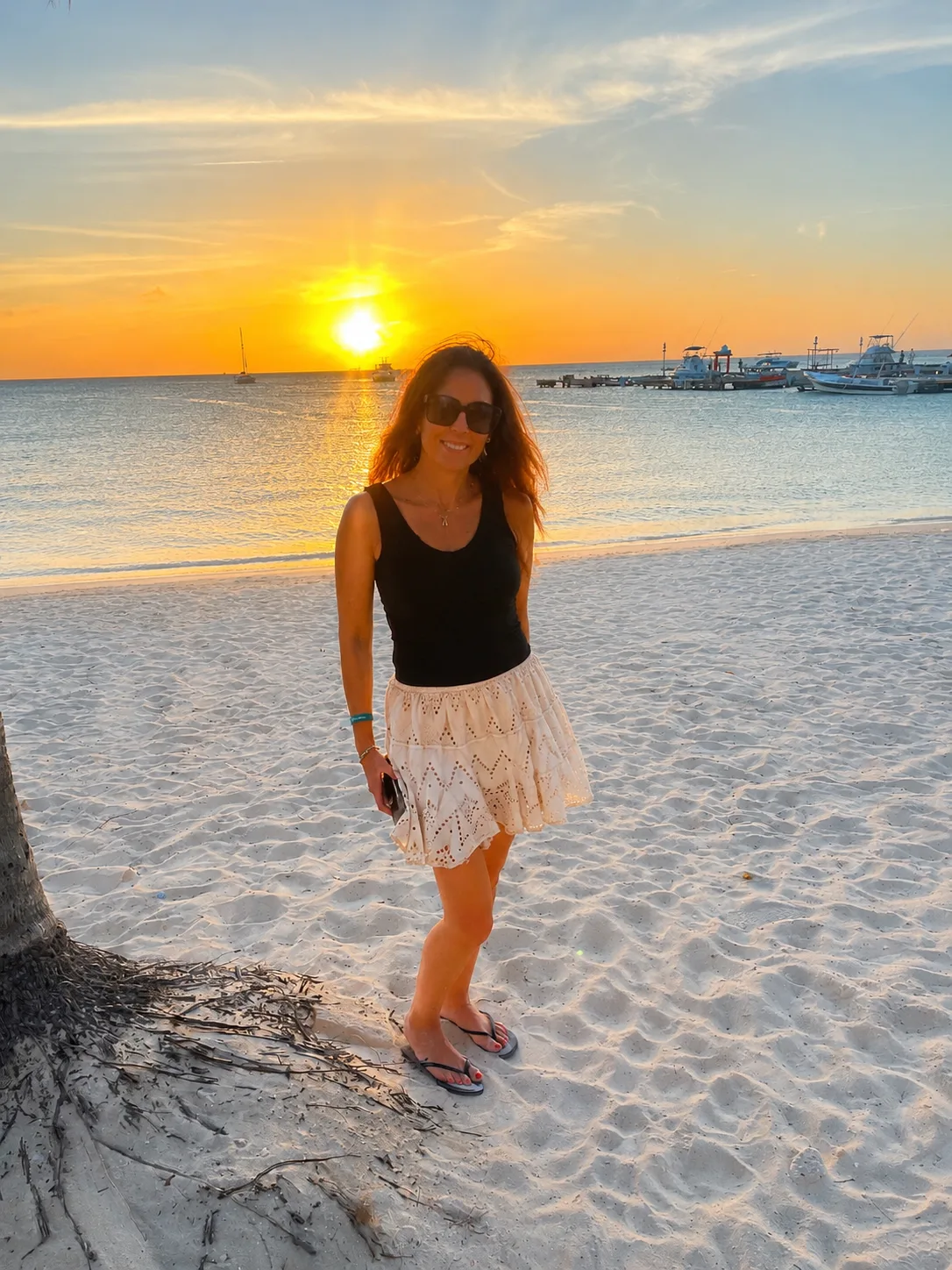 Woman standing on beach at sunset in Aruba
